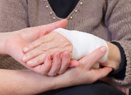 Picture of doctor's hand making a bandage for an elderly hand